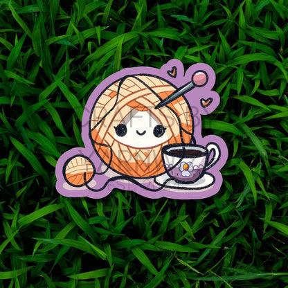 a sticker of a yarn ball and a cup of coffee