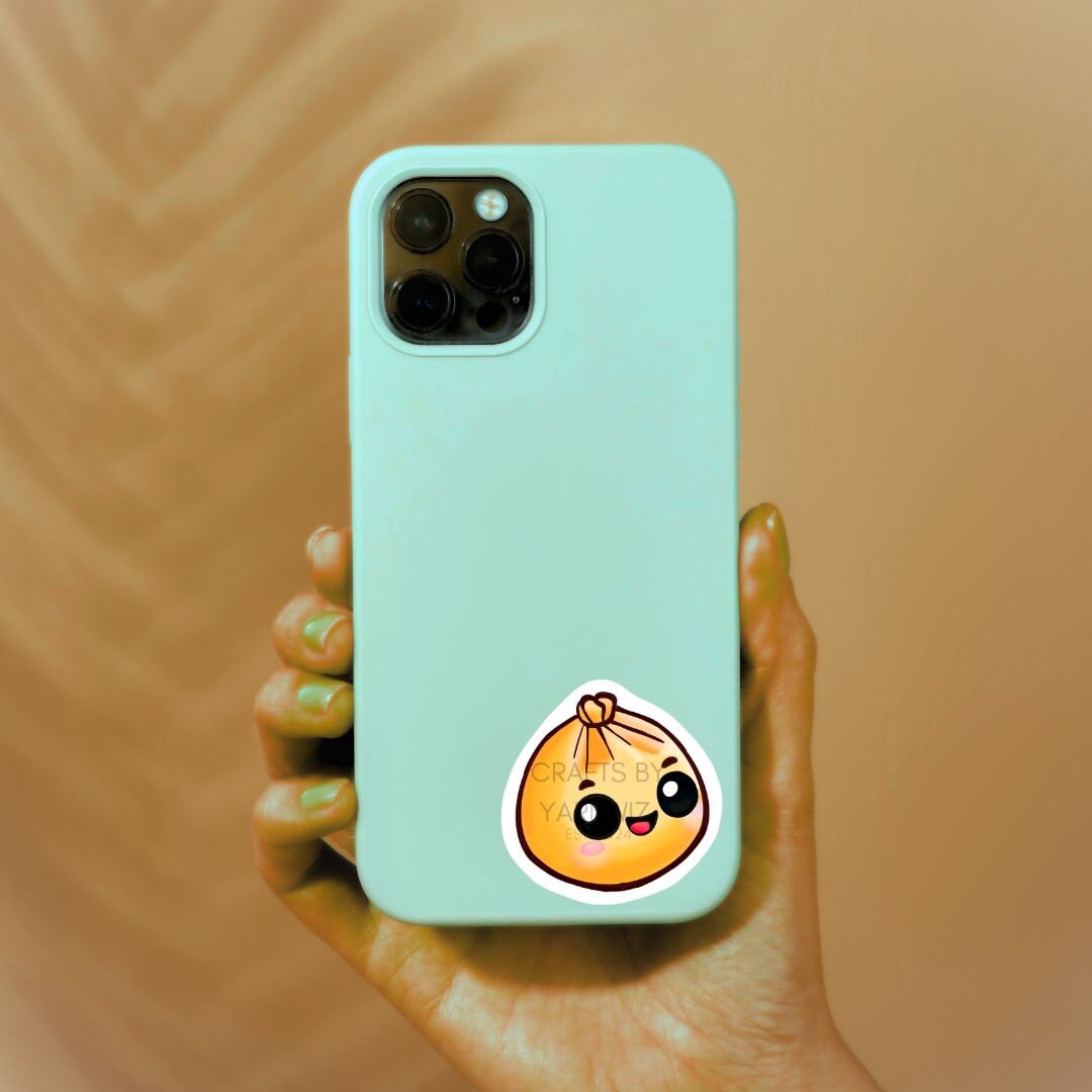 a person holding a phone with a sticker on it