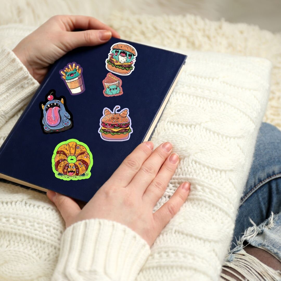 a person holding a book with stickers on it