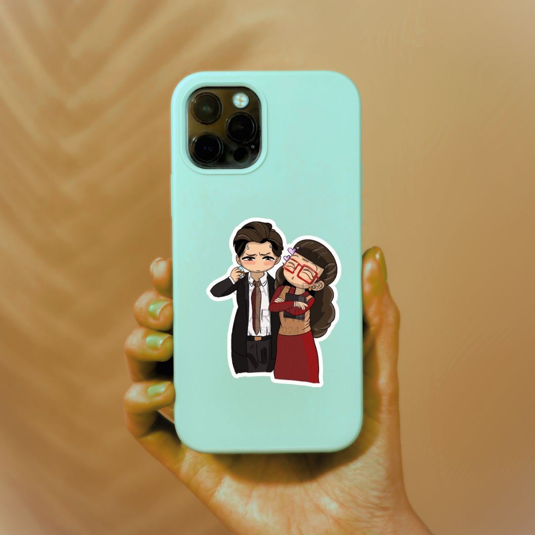 a person holding a phone case with a sticker of two people on it