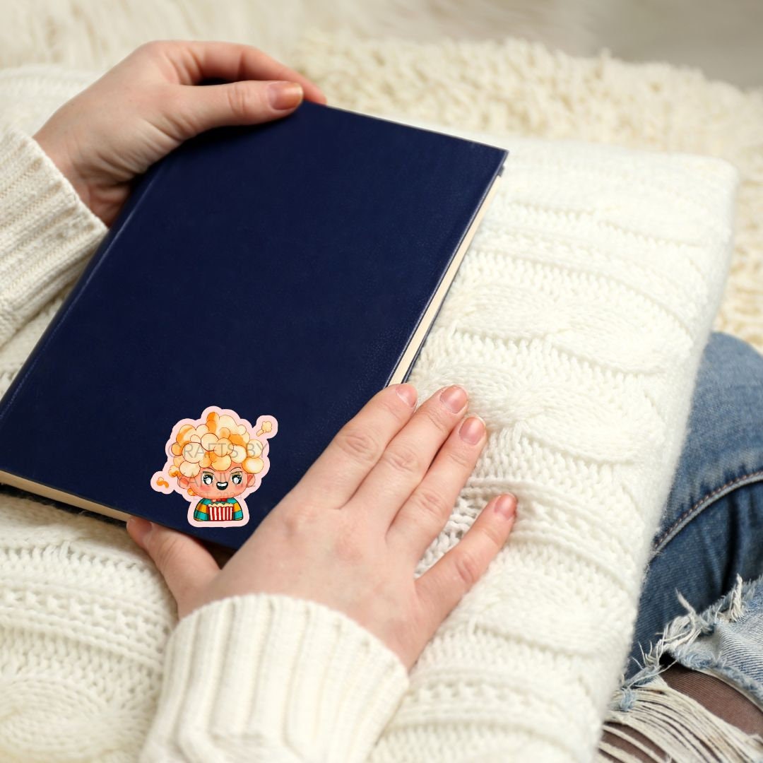 a person holding a book with a tiger sticker on it