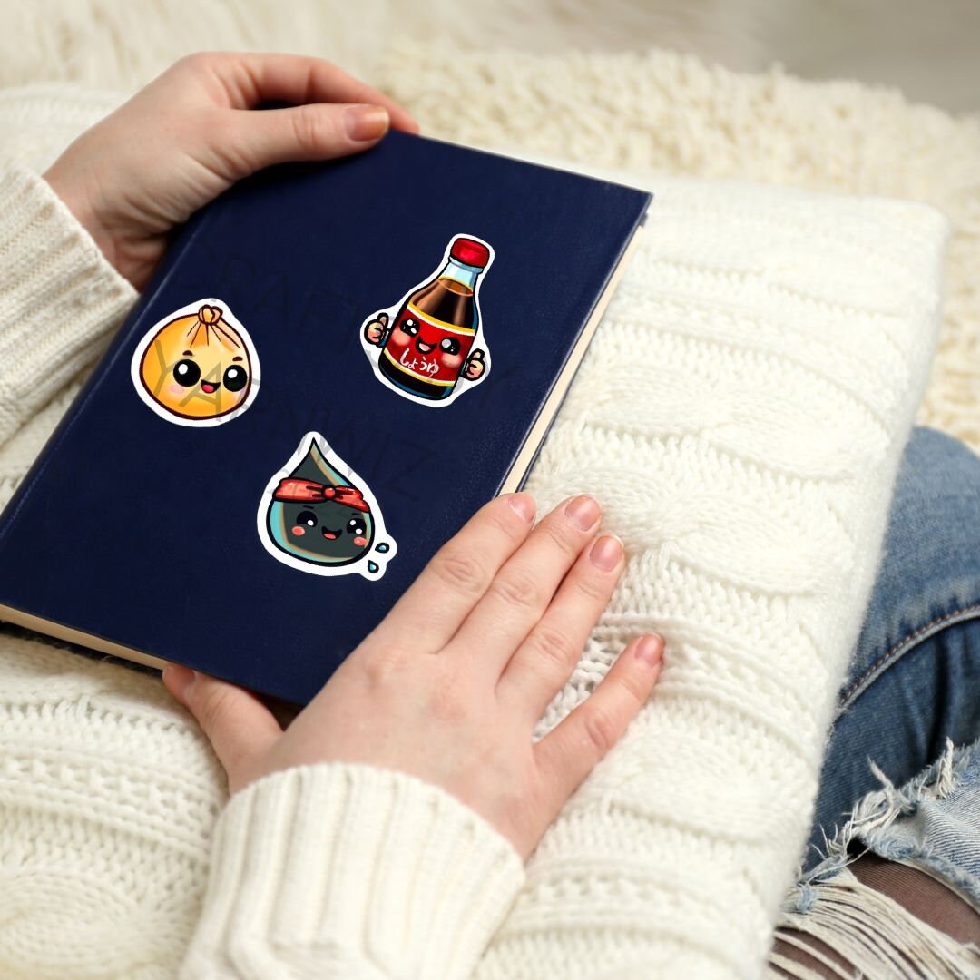 a person holding a book with stickers on it