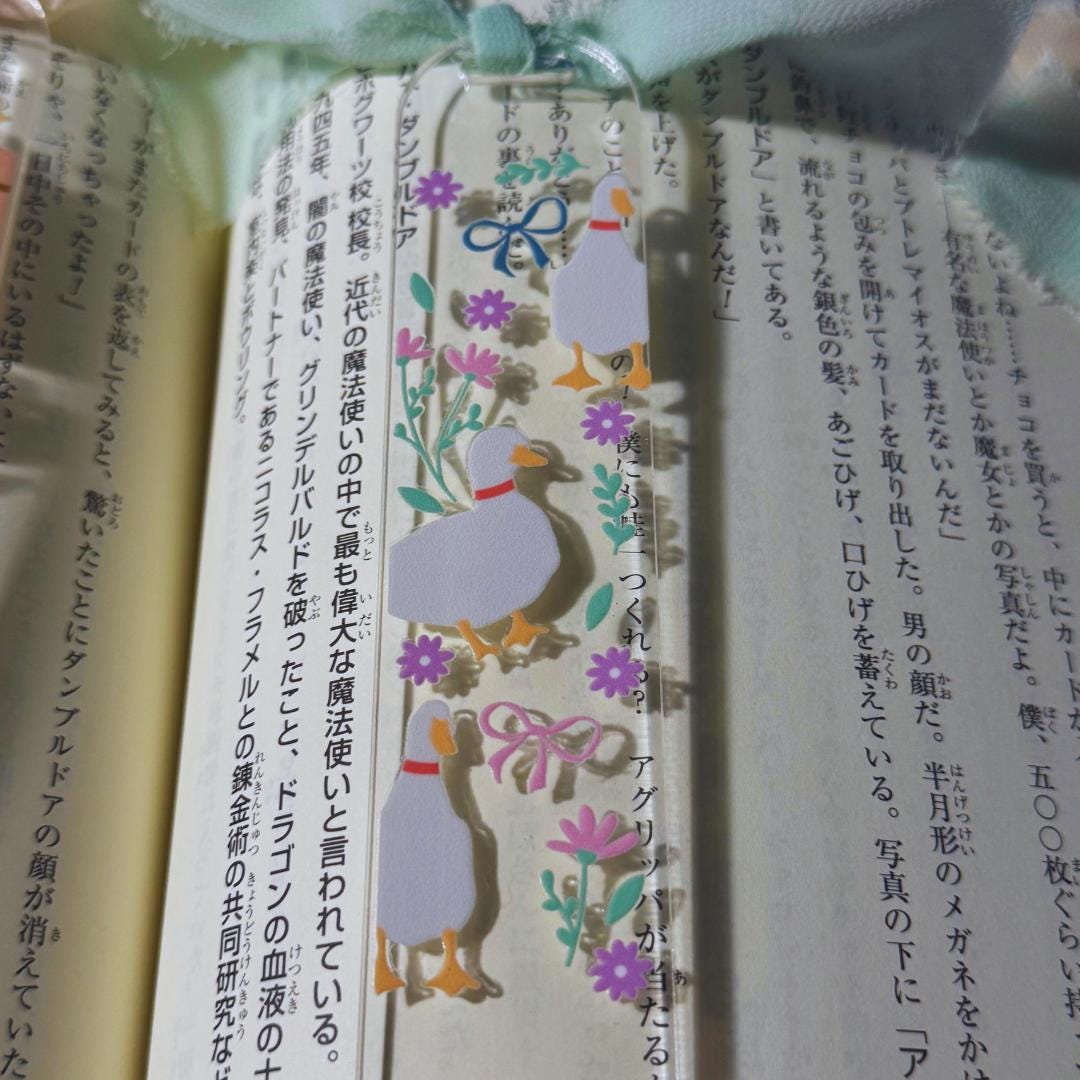 a bookmark with a penguin and flowers on it